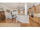 Open-concept kitchen and dining area with hardwood floors, wooden cabinets, granite countertops, and modern appliances at 2027 Hopeton Ave, Raleigh, NC 27614