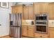 Kitchen with stainless steel refrigerator, oven, and microwave, with light wood cabinets at 2027 Hopeton Ave, Raleigh, NC 27614