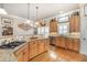 Well-appointed kitchen featuring granite countertops, stainless steel appliances, wood cabinets, and a gas cooktop on the island at 2027 Hopeton Ave, Raleigh, NC 27614