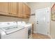 Laundry room with modern washer and dryer, ample cabinets, and access to the exterior at 2027 Hopeton Ave, Raleigh, NC 27614