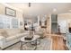 Inviting living room with hardwood floors, a comfortable sofa, and an open floor plan leading to the dining area and kitchen at 2027 Hopeton Ave, Raleigh, NC 27614