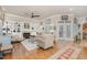 Spacious living room with a fireplace, built-in shelves, hardwood floors, and French doors leading to an outdoor space at 2027 Hopeton Ave, Raleigh, NC 27614