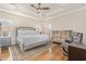 Main bedroom featuring a tray ceiling, with a cozy sitting area, and classic furniture at 2027 Hopeton Ave, Raleigh, NC 27614
