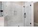 Modern shower featuring white marble-style tile, a glass door, and chrome fixtures at 2027 Hopeton Ave, Raleigh, NC 27614