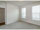 Bright bedroom featuring two large windows, neutral carpeting, and freshly painted walls at 209 Stone River Dr, Wendell, NC 27591