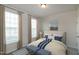 This bedroom has a cozy feel with two benches, matching side tables, two windows, and decor at 209 Stone River Dr, Wendell, NC 27591