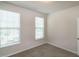 This bedroom features two windows, neutral carpeting, and freshly painted walls at 209 Stone River Dr, Wendell, NC 27591