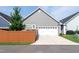 Gray home features a white garage door and a brown privacy fence in the front yard at 209 Stone River Dr, Wendell, NC 27591