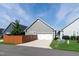 View of home with a white garage door, gray siding, and brown privacy fence at 209 Stone River Dr, Wendell, NC 27591