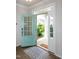 Stylish entryway with an open turquoise door, patterned rug, and light wood floors at 209 Stone River Dr, Wendell, NC 27591
