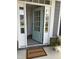 Welcoming entrance with an open turquoise door, inviting doormat and side windows at 209 Stone River Dr, Wendell, NC 27591