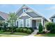 Charming home features a landscaped front yard, gray siding, and a welcoming turquoise front door at 209 Stone River Dr, Wendell, NC 27591