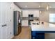 Modern kitchen with stainless steel fridge, white cabinets, and a large island with sink at 209 Stone River Dr, Wendell, NC 27591