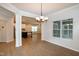 Open-concept space featuring wood floors, white pillars, and a glimpse of the kitchen at 209 Stone River Dr, Wendell, NC 27591