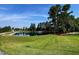 Scenic community pond featuring a fountain, trees, and well-maintained green grass at 209 Stone River Dr, Wendell, NC 27591