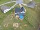 Aerial view of a white two-story home, featuring a deck and above-ground pool, set within a spacious lawn at 241 Fox Run, Benson, NC 27504