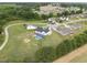 Aerial view of a two-story home with a pool in a residential area with tree-lined streets and open fields at 241 Fox Run, Benson, NC 27504