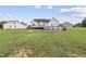 View of backyard featuring a white two-story home with an above ground pool and spacious lawn with fire pit at 241 Fox Run, Benson, NC 27504