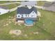 View of backyard featuring a white two-story home with an above ground pool and spacious lawn with fire pit at 241 Fox Run, Benson, NC 27504