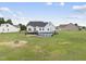 View of backyard featuring a white two-story home with an above ground pool and spacious lawn with fire pit at 241 Fox Run, Benson, NC 27504