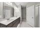 Bathroom boasts double sink vanity with white countertops, a large mirror and tile floors at 241 Fox Run, Benson, NC 27504