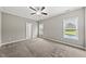 Bedroom features carpet, ceiling fan, two windows overlooking the pool and light gray walls at 241 Fox Run, Benson, NC 27504