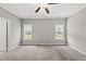Bedroom with carpet, ceiling fan, two windows with a view of the yard, light gray walls at 241 Fox Run, Benson, NC 27504