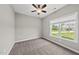 Bedroom with carpet, ceiling fan, light gray walls and one window with a view of the yard at 241 Fox Run, Benson, NC 27504