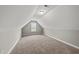 This is a carpeted bonus room with vaulted ceilings, light grey paint, and a window at 241 Fox Run, Benson, NC 27504