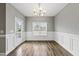 Elegant dining room with chair railing, hardwood floors, a modern chandelier, and natural light at 241 Fox Run, Benson, NC 27504