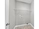 Neutral laundry room with tile floors and wire shelving above the washer and dryer connections at 241 Fox Run, Benson, NC 27504