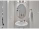 Bright powder room features pedestal sink, oval mirror and brushed nickel fixtures at 243 E Wellesley Dr, Clayton, NC 27520