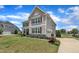 Side view of an elegant home with attached garage, paved driveway and landscaped yard at 243 E Wellesley Dr, Clayton, NC 27520