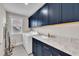 Laundry room with front load washer and dryer, sink and dark blue cabinets at 243 E Wellesley Dr, Clayton, NC 27520