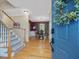 Inviting foyer with hardwood floors and staircase leading to dining room with decorative light fixture at 244 Elmcrest Dr, Holly Springs, NC 27540