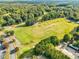 Aerial view of lush green golf course in a wooded landscape at 244 Elmcrest Dr, Holly Springs, NC 27540