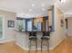 Open kitchen with a breakfast bar, modern stools, and hardwood floors, ideal for casual dining at 244 Elmcrest Dr, Holly Springs, NC 27540