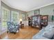 Cozy living room featuring hardwood floors, a patterned armchair, and abundant natural light at 244 Elmcrest Dr, Holly Springs, NC 27540