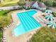 Aerial view of a community pool area with lounge chairs, umbrellas, and a pool house in a residential neighborhood at 244 Elmcrest Dr, Holly Springs, NC 27540
