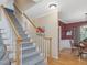 Carpeted staircase with wooden handrails and wainscoting details at 244 Elmcrest Dr, Holly Springs, NC 27540