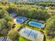 Aerial view of tennis courts surrounded by lush trees, offering a scenic and private recreational space at 244 Elmcrest Dr, Holly Springs, NC 27540