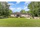 Spacious backyard with lush lawn, mature trees, screened porch, and a cozy fire pit area for outdoor enjoyment at 281 Kinsman Ct, Fuquay Varina, NC 27526