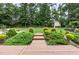 Expansive backyard featuring lush landscaping, wooden walkway, and manicured lawn at 281 Kinsman Ct, Fuquay Varina, NC 27526