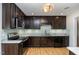 Modern kitchen with dark cabinets, stainless steel appliances, light backsplash, and hardwood floors at 281 Kinsman Ct, Fuquay Varina, NC 27526