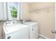 Functional laundry room with washer, dryer, and shelving for storage solutions at 281 Kinsman Ct, Fuquay Varina, NC 27526