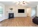 Open living room features a fireplace, a large window for natural light, and hardwood flooring at 281 Kinsman Ct, Fuquay Varina, NC 27526