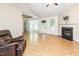 Bright living room with hardwood floors, fireplace, natural light from a bay window, and a leather recliner at 281 Kinsman Ct, Fuquay Varina, NC 27526