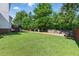 A spacious, well-maintained lawn features a wooden fence and lush trees providing shade and privacy at 2933 Creek Moss Ave, Wake Forest, NC 27587