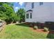 Manicured lawn, partial view of a wooden deck, and the rear of the house are featured in this backyard at 2933 Creek Moss Ave, Wake Forest, NC 27587