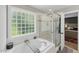 This bathroom features a soaking tub, a glass shower and natural light at 2933 Creek Moss Ave, Wake Forest, NC 27587